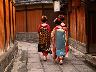 Geisha's door de straten van de wijk Gion in Kyoto
