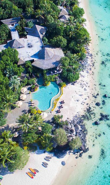 Het Pacific Resort Aitutaki vanaf boven gefotografeerd met de heldere oceaan en zwembad.