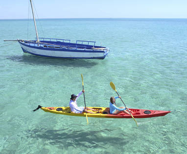4._Azura_Benguerra_-_Kayaking_past_a_dhow