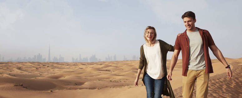 Stel in de woestijn met Dubai op de achtergrond