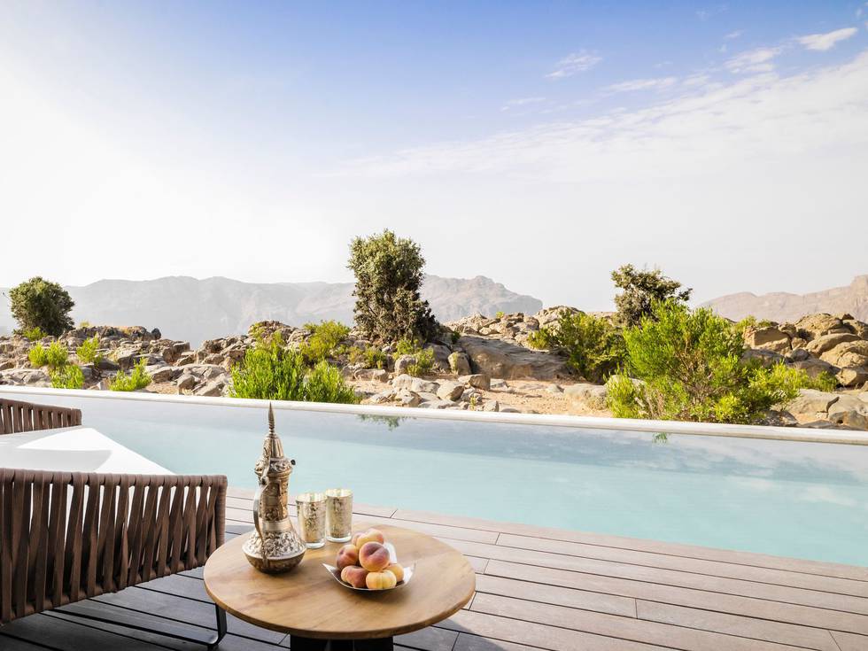 Stoel bij zwembad met uitzicht over Hadjargebergte