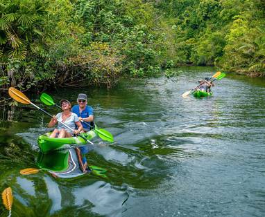 CM_4_Rivers_Floating_Lodge_Cambodja_kajakken_man-and-woman-laugh-while-rowing-on-river