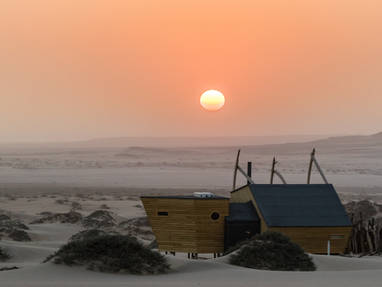 maan/zon op de achtergrond bij shipwreck lodge in Namibië