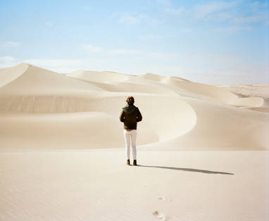 gast uitkijkend over de duinen bij shipwreck lodge in Namibië