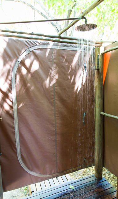 Ensuite badkamer met buitendouche bij Sango Safari Camp in Botswana