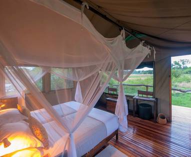 Slaapkamer met uitzicht bij Sango Safari Camp in Botswana - licht