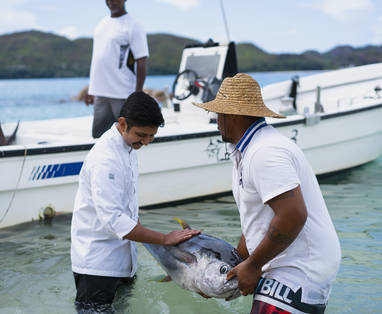 Chefkok en visser met grote vers gevangen vis uit de zee bij Raffles Seychelles