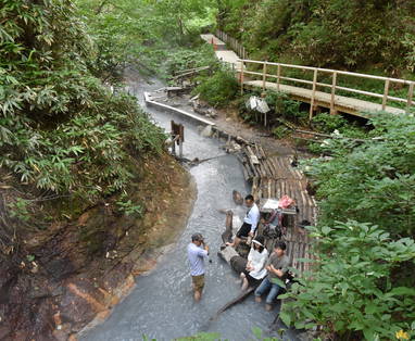 Mensen nemen voetenbad bij warmwaterbron op Hokkaido