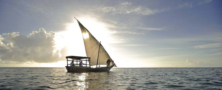 Varen met een dhow zeilboot bij zonsondergang Mnemba Island 