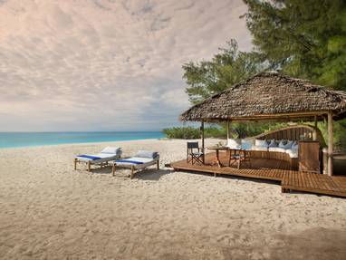 Prive strand met ligbedden op Mnemba Island 