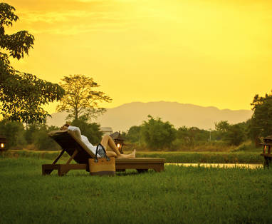 Ligbed met uitzicht op de rivier bij The Legend Resort in Thailand