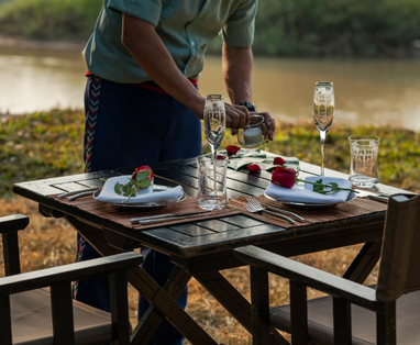 Ober dekt de tafel bij Four Seasons Golden Triangle in Chiang Rai