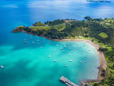 Een baai bij Waiheke island in Nieuw-Zeeland met turkoois blauwe zee en zeilboten. 