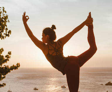 Een dame die een yoga pose doet bij een infinity pool in het Pimalai Resort in Thailand.