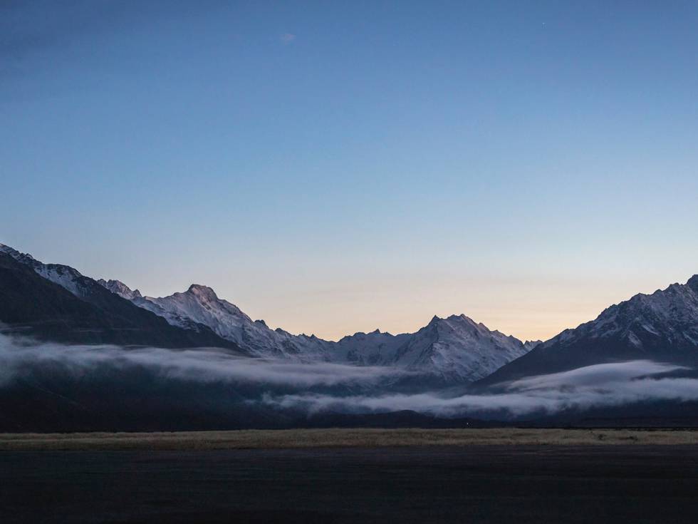 De bergen van het Mt Cook Nationaal Park in Nieuw-Zeeland met ondergaande zon. 