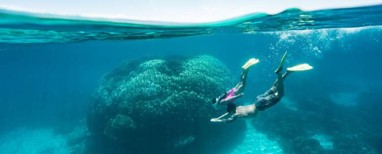 Een man geniet van het snorkelen in de oceaan bij een koraalrif op Wilson Island, Queensland in Australië.