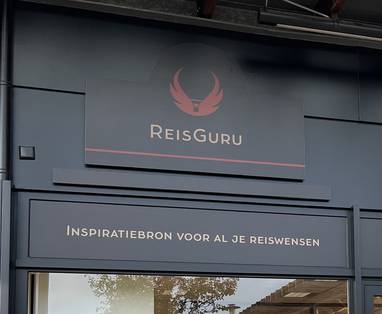 Een foto van het ReisGuru logo bij een reisbureau in Roelofarendsveen. 
