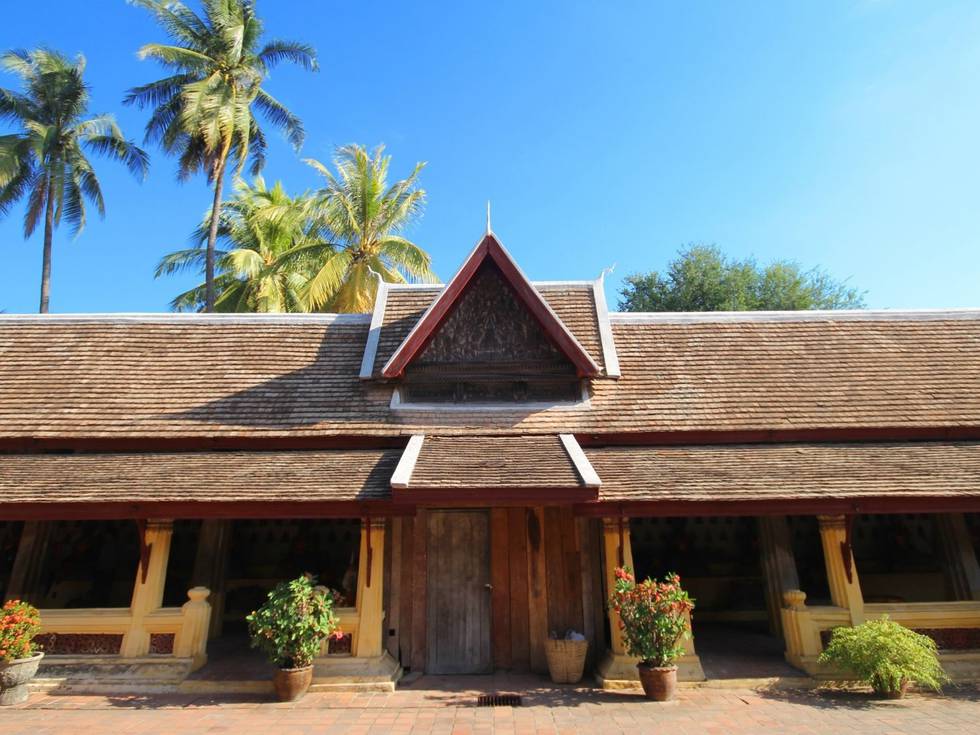 De Wat Si Shaket tempel in Vietnam met op de achtergrond palmbomen. 