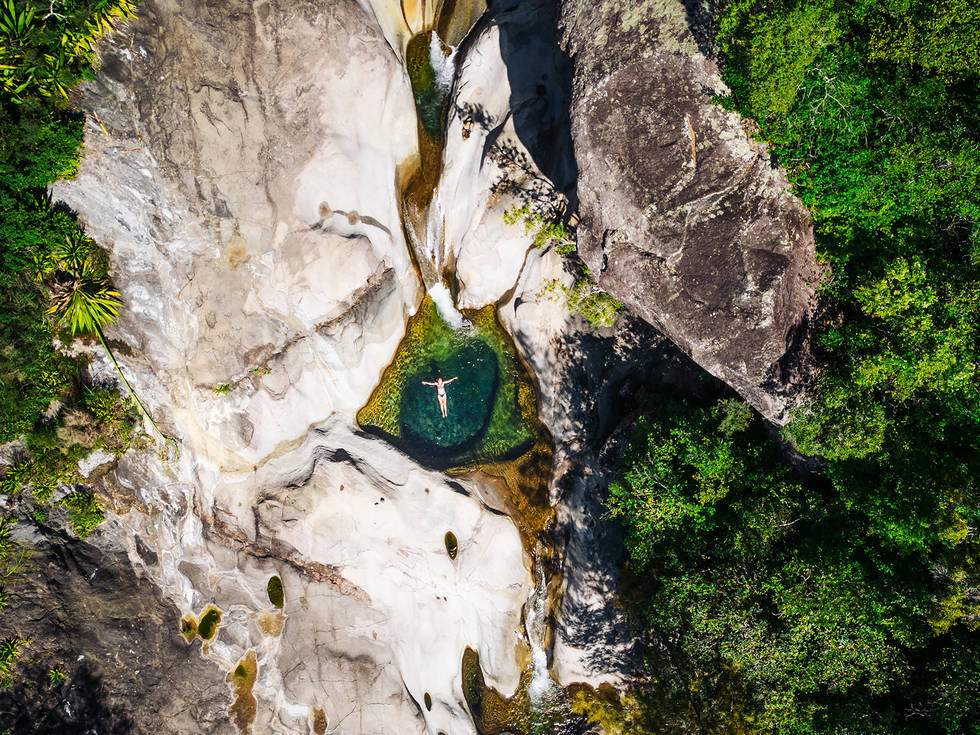 De Cirque de Cilaos van bovenaf gefotografeerd met een dame die in het water ligt. 