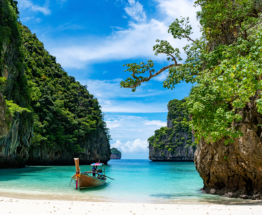 Een baai in Thailand met een lokale bewoner die op een boot staat. 