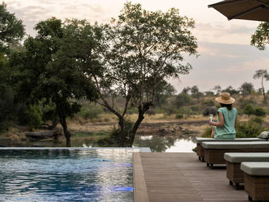 Tanda Tula vrouw kijkt uit naar olifanten bij de drinkplaats