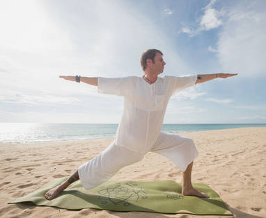 Yoga les op het strand bij Aleenta Phuket in Thailand