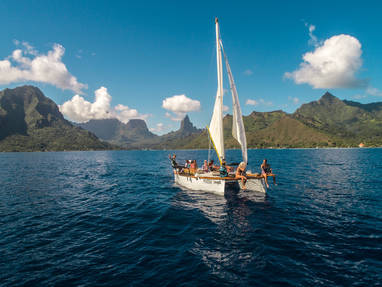 Vooraanzicht van lokale zeilboot op zee met de bergen op de achtergrond
