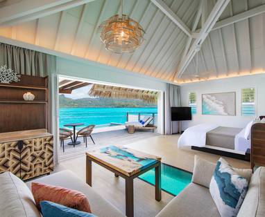 Binnenaanzicht overwater bungalow met ruimte inrichting en uitzicht op zee